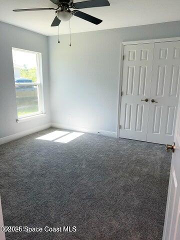 carpeted spare room featuring ceiling fan