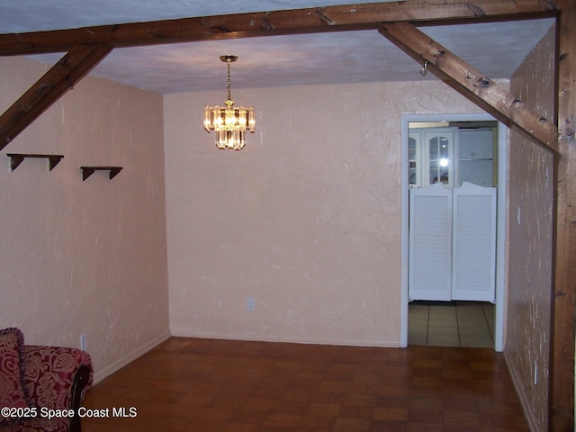 unfurnished dining area featuring an inviting chandelier, dark parquet flooring, and beam ceiling