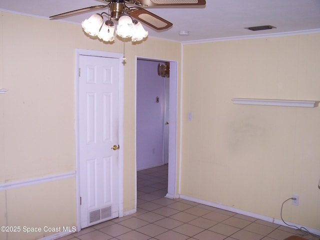 tiled spare room with ceiling fan and ornamental molding