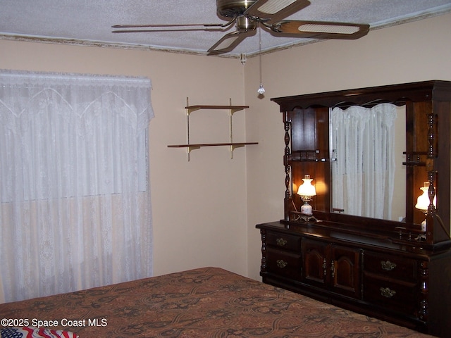 bedroom with ceiling fan and a textured ceiling