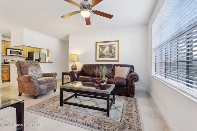 tiled living room with ceiling fan and a healthy amount of sunlight