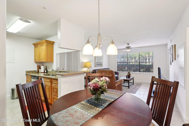 dining space featuring ceiling fan with notable chandelier, light tile patterned floors, and sink