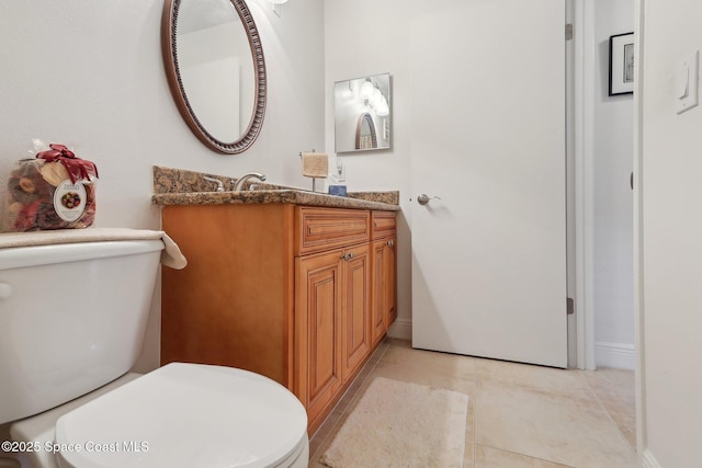 bathroom featuring tile patterned flooring, vanity, and toilet