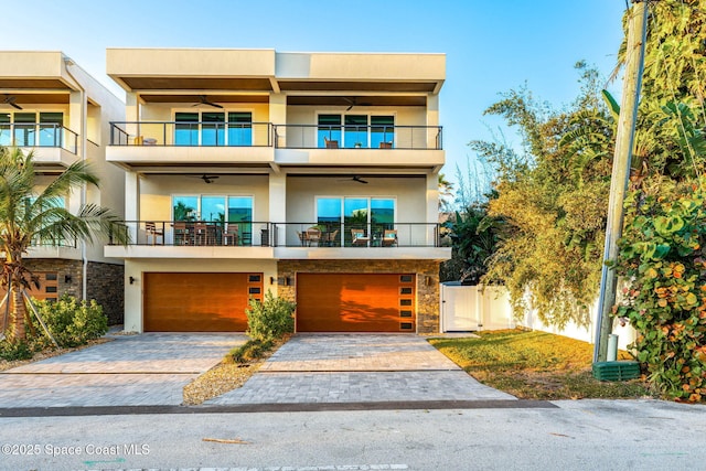 contemporary home with ceiling fan, a garage, and a balcony