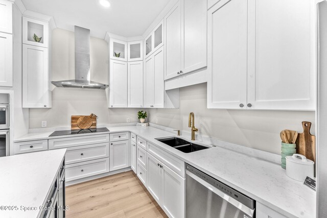 kitchen featuring dishwasher, wall chimney exhaust hood, white cabinetry, sink, and black electric cooktop