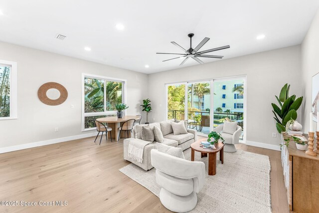 living room with ceiling fan and light hardwood / wood-style floors