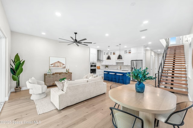 living room featuring light hardwood / wood-style floors and ceiling fan