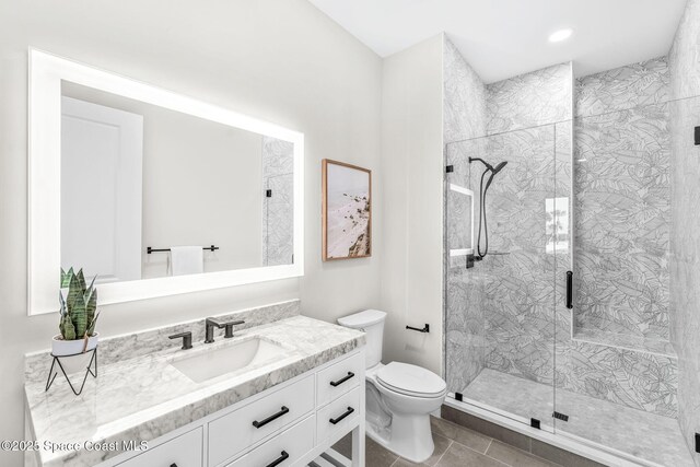 bathroom with toilet, vanity, tile patterned flooring, and a shower with door