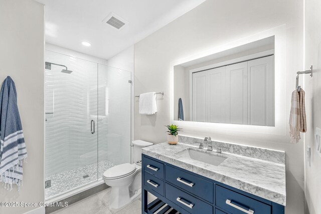 bathroom with toilet, vanity, tile patterned flooring, and an enclosed shower