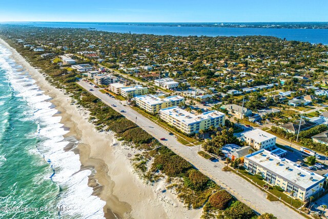 drone / aerial view featuring a water view and a view of the beach