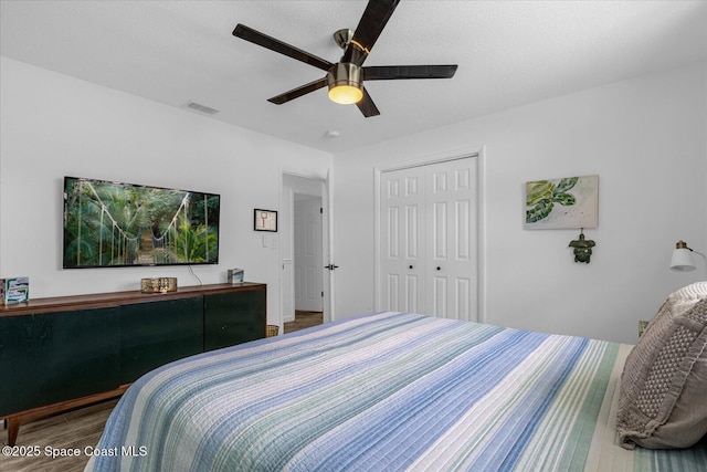 bedroom featuring ceiling fan, a closet, and hardwood / wood-style floors