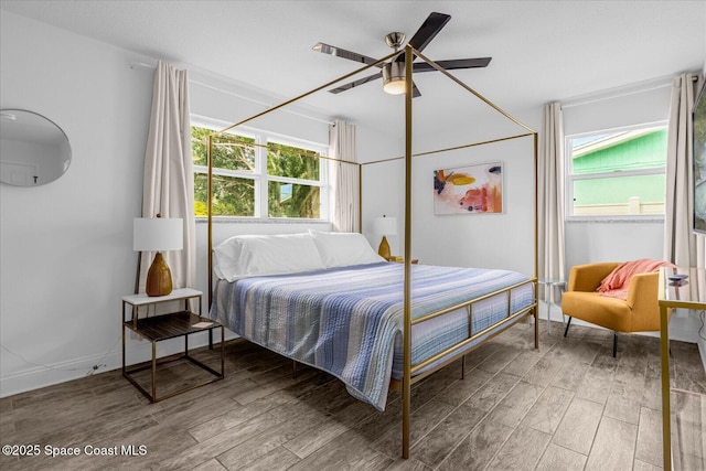 bedroom with multiple windows, ceiling fan, and hardwood / wood-style flooring