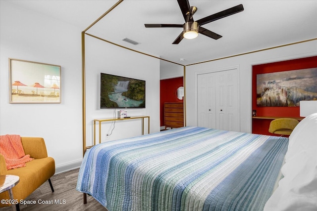 bedroom with a closet, hardwood / wood-style flooring, and ceiling fan