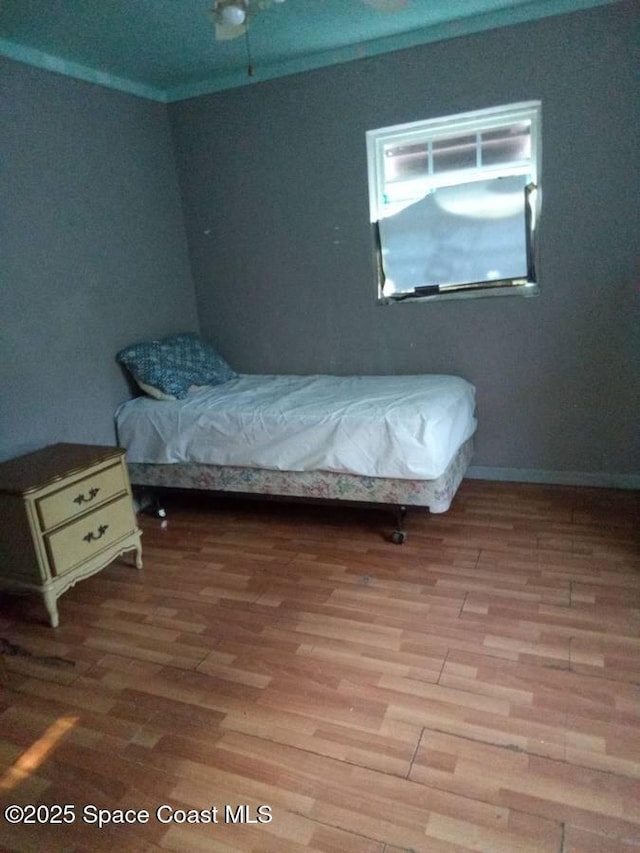 bedroom with wood-type flooring and crown molding