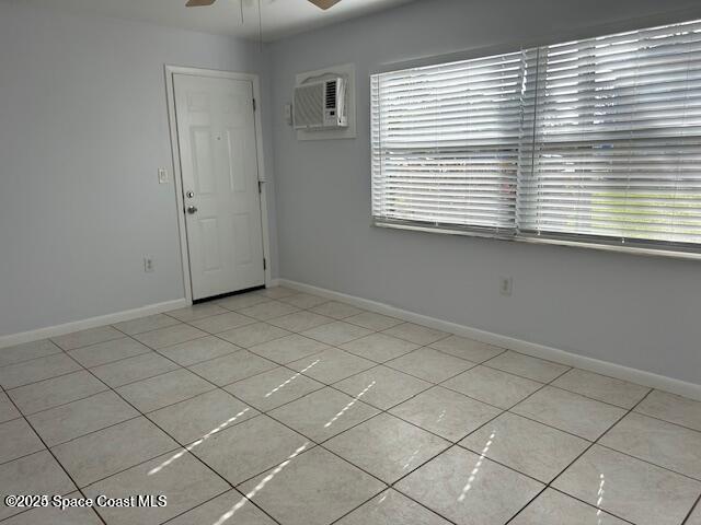 380 N Brevard Ave Unit C-1, Cocoa Beach, FL 32931 - spare room featuring a wall unit AC, ceiling fan, and light tile patterned floors