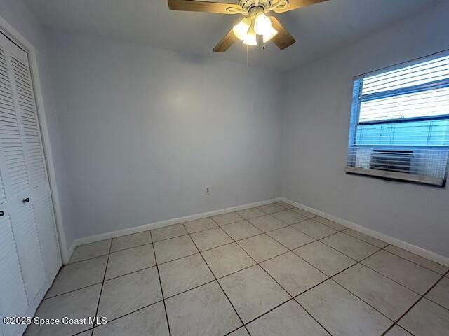 tiled empty room featuring ceiling fan