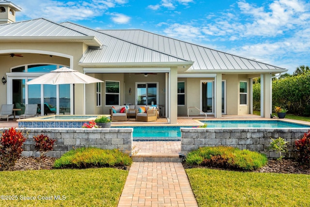 rear view of property with ceiling fan, a swimming pool with hot tub, an outdoor hangout area, and a patio