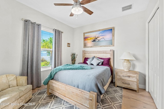 bedroom with hardwood / wood-style flooring, ceiling fan, and a closet