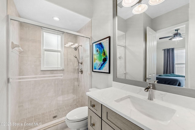 bathroom featuring ceiling fan, vanity, toilet, and a shower with shower door