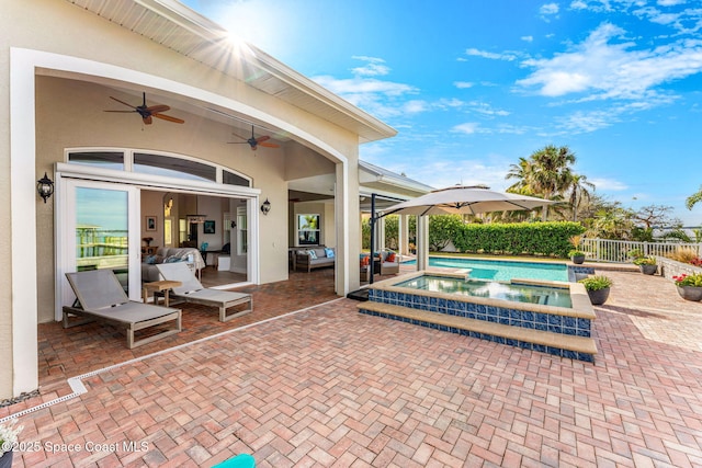 view of pool featuring a patio area, ceiling fan, and an in ground hot tub