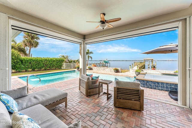 view of patio / terrace featuring a water view, ceiling fan, an outdoor living space, and a fenced in pool