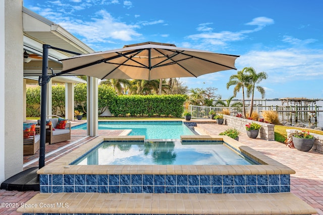 view of swimming pool featuring a patio area and an in ground hot tub