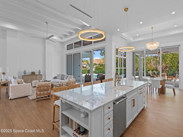 kitchen with light wood-style flooring, a sink, open shelves, recessed lighting, and a raised ceiling