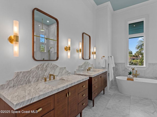 bathroom featuring a soaking tub, a stall shower, marble finish floor, and a sink