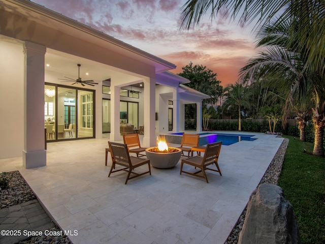 view of patio with a fenced in pool, a fire pit, ceiling fan, and fence