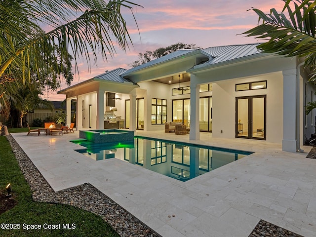 view of pool with a pool with connected hot tub, french doors, outdoor lounge area, a ceiling fan, and a patio