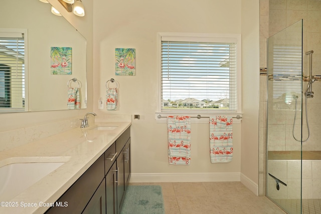 bathroom featuring tile patterned flooring, vanity, and tiled shower