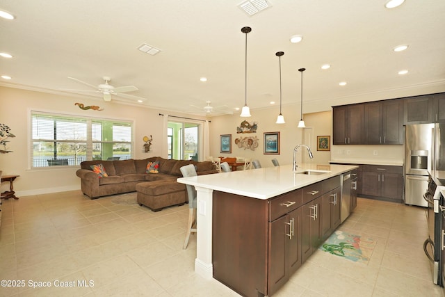 kitchen with appliances with stainless steel finishes, an island with sink, ceiling fan, and sink