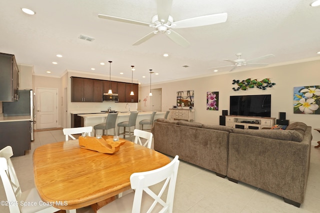 dining room with light tile patterned floors, ceiling fan, and crown molding