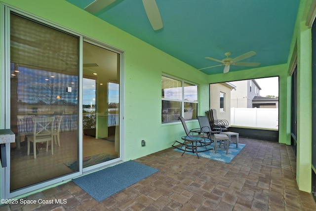 unfurnished sunroom with ceiling fan