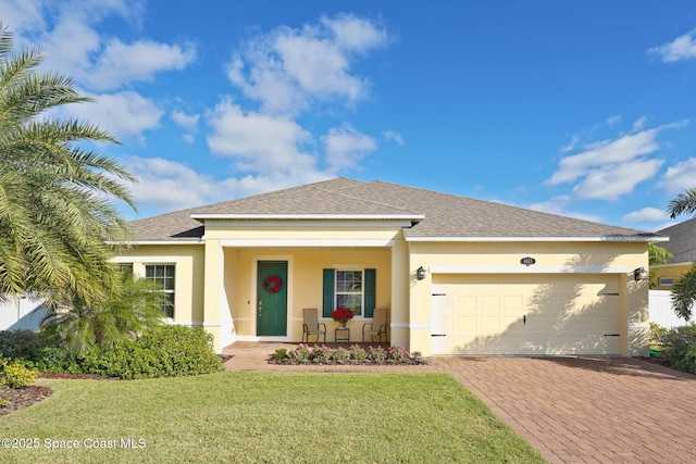 view of front of property featuring a front lawn, covered porch, and a garage