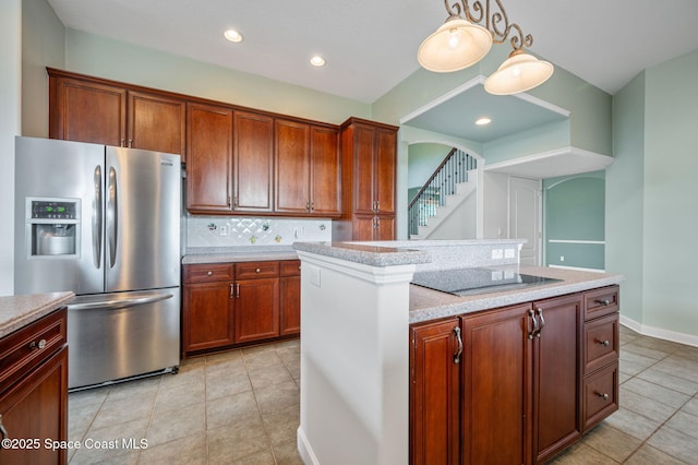 kitchen with stainless steel refrigerator with ice dispenser, black electric stovetop, tasteful backsplash, light stone counters, and pendant lighting