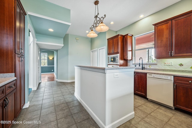 kitchen featuring decorative backsplash, hanging light fixtures, light tile patterned floors, dishwasher, and stainless steel microwave