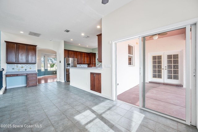 kitchen featuring decorative backsplash, stainless steel refrigerator with ice dispenser, and french doors