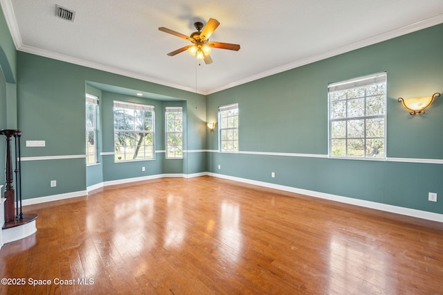 empty room with wood-type flooring, ceiling fan, and crown molding