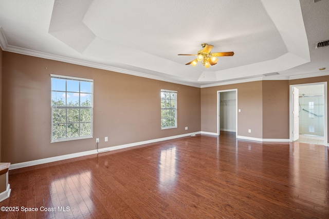 empty room featuring a tray ceiling, ceiling fan, crown molding, and hardwood / wood-style flooring