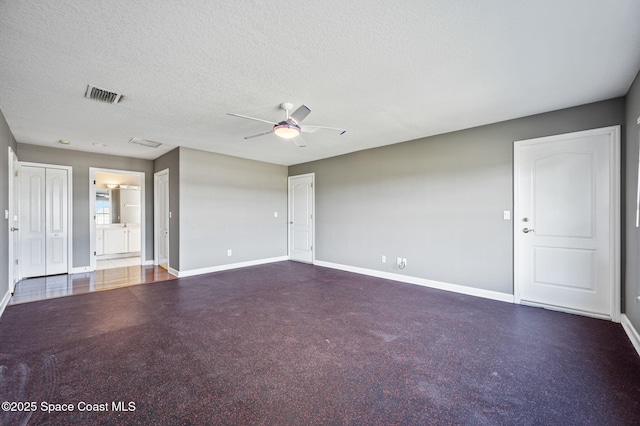 empty room with ceiling fan and a textured ceiling