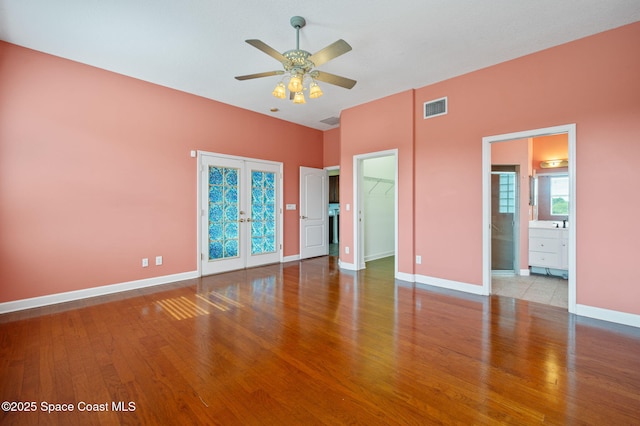 interior space featuring french doors, ceiling fan, light hardwood / wood-style flooring, a spacious closet, and connected bathroom