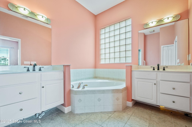 bathroom featuring vanity and a relaxing tiled tub