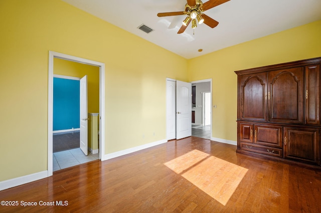 unfurnished bedroom with connected bathroom, light hardwood / wood-style flooring, and ceiling fan