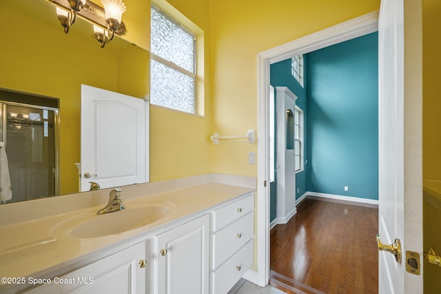 bathroom featuring hardwood / wood-style floors, vanity, and a shower with shower door