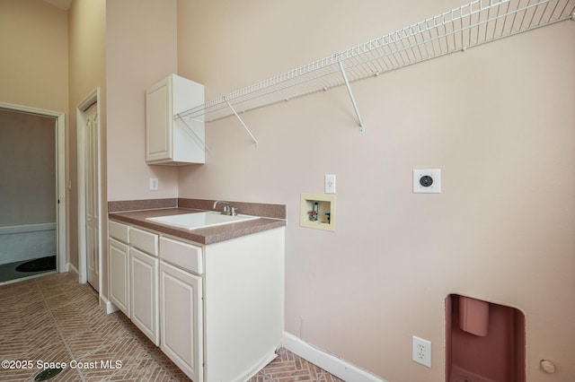 clothes washing area featuring hookup for an electric dryer, washer hookup, cabinets, and sink