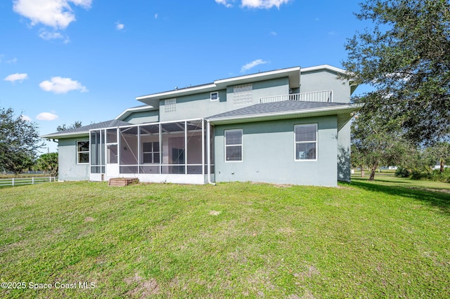 rear view of house featuring a lawn and a lanai