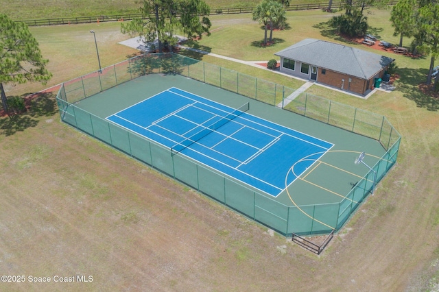 exterior space with basketball hoop and a yard