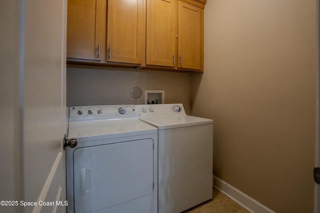 clothes washing area featuring washer and dryer, cabinets, and light tile patterned flooring