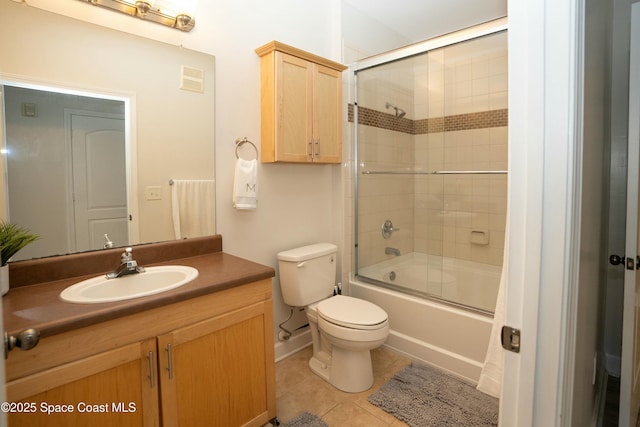 full bathroom with toilet, tile patterned flooring, vanity, and combined bath / shower with glass door